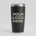 A matte black insulated travel tumbler with a clear lid, featuring the placeholder text 'YOUR LOGO HERE' in light beige. The tumbler is photographed on a seamless light gray background.